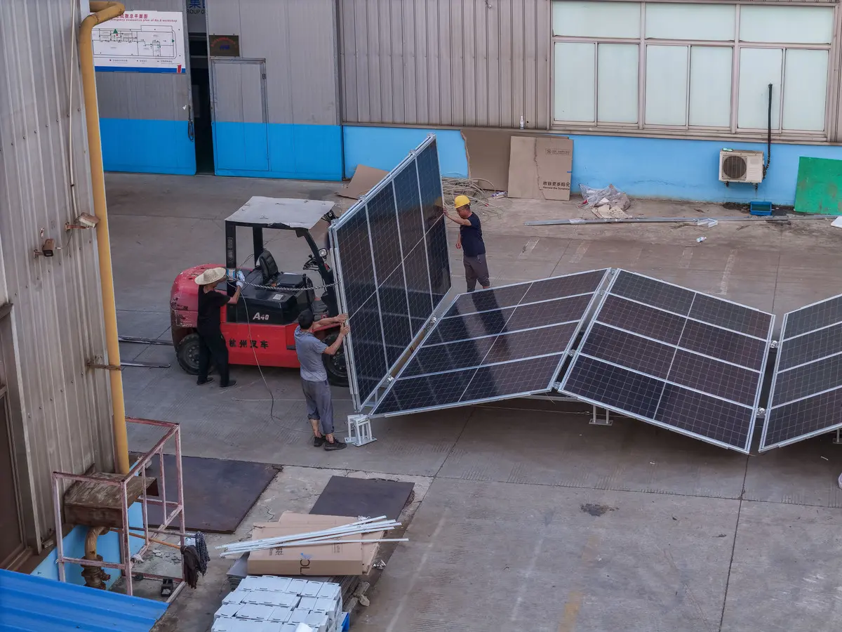 Construction workers are unfolding the solar container's solar panels